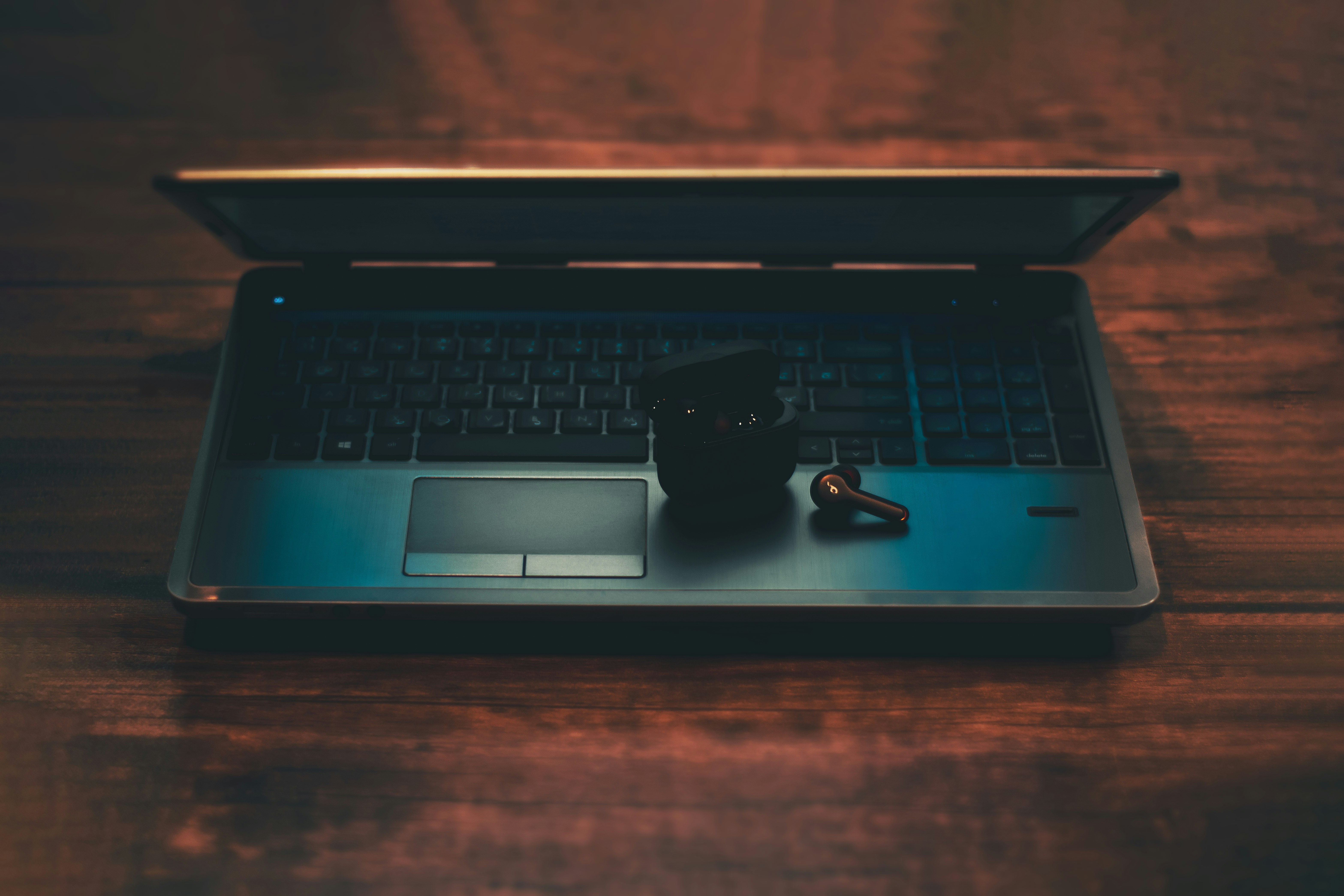 black and gray laptop computer with black corded mouse on brown wooden table